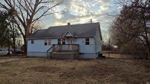 bungalow-style house featuring a lawn and a deck