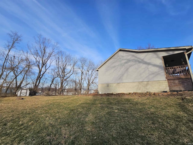 view of side of home featuring a lawn and a storage shed