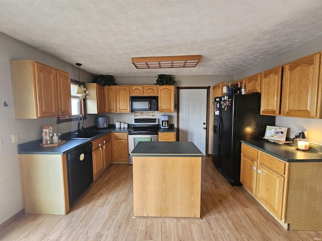 kitchen featuring sink, hanging light fixtures, a kitchen island, light hardwood / wood-style floors, and black appliances