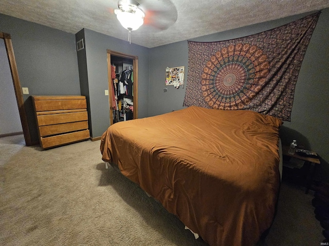 carpeted bedroom featuring ceiling fan, a spacious closet, a textured ceiling, and a closet