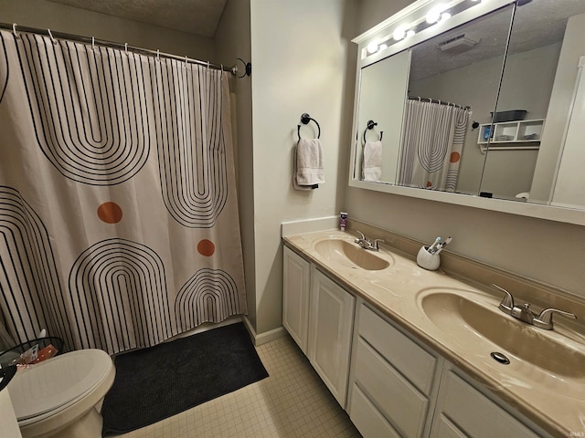 bathroom with vanity, tile patterned flooring, a textured ceiling, and toilet