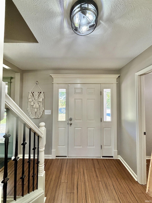 foyer featuring hardwood / wood-style floors and a textured ceiling