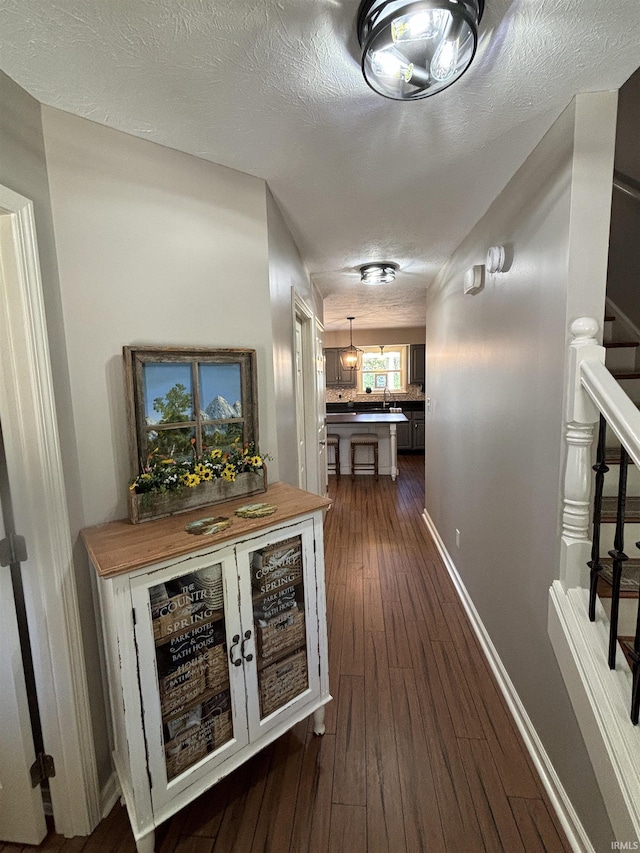 hallway featuring dark hardwood / wood-style floors and a textured ceiling