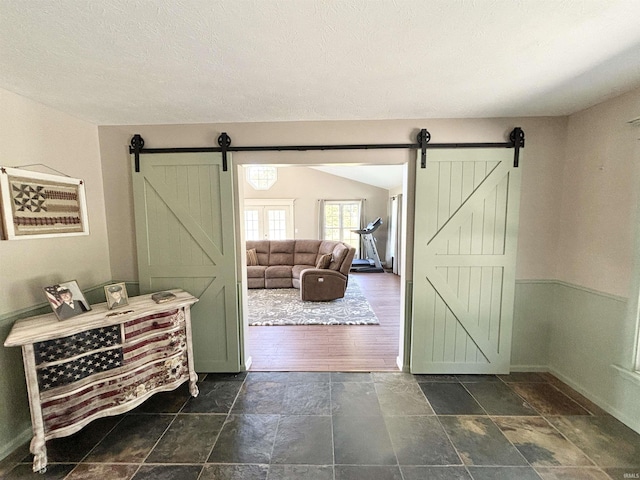 foyer with a barn door and a textured ceiling