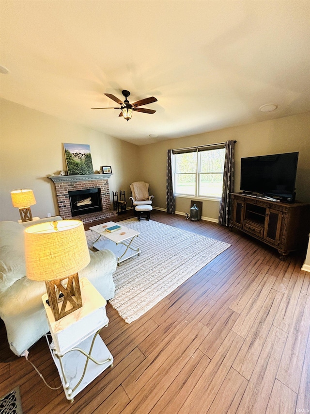 living room featuring hardwood / wood-style flooring, a fireplace, and ceiling fan