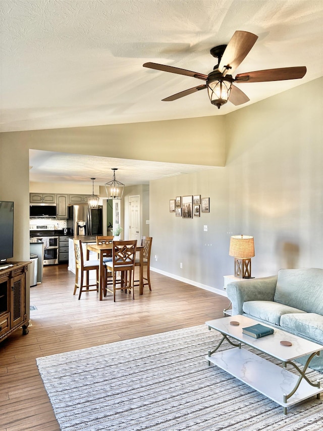 living room with hardwood / wood-style flooring, vaulted ceiling, and a textured ceiling