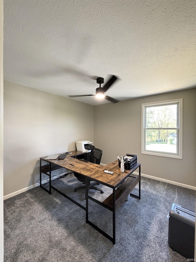 carpeted office featuring a textured ceiling and ceiling fan