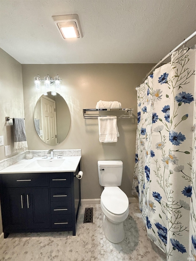 bathroom with vanity, a textured ceiling, toilet, and walk in shower