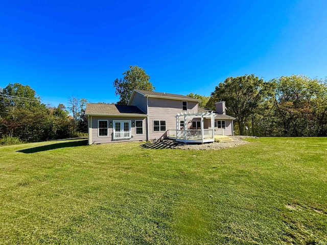 back of house featuring a wooden deck, a yard, and a pergola