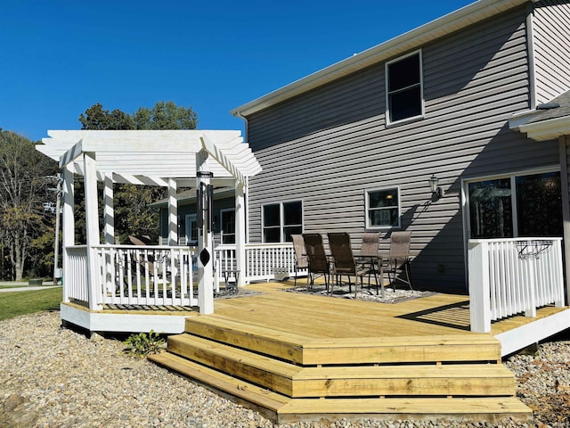 rear view of house with a wooden deck and a pergola