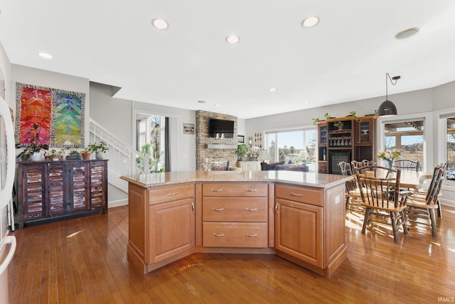 kitchen with light stone counters, hanging light fixtures, and a center island