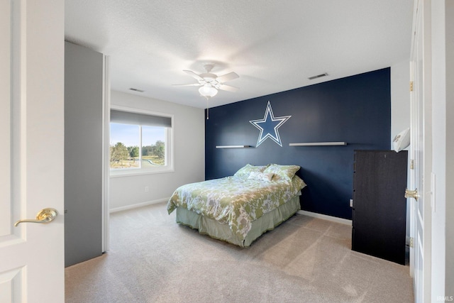 bedroom with a textured ceiling, ceiling fan, and carpet flooring