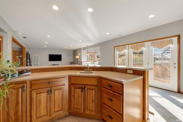 kitchen featuring sink, light carpet, and kitchen peninsula