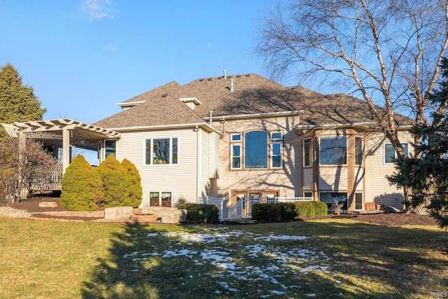 rear view of house with a pergola and a lawn