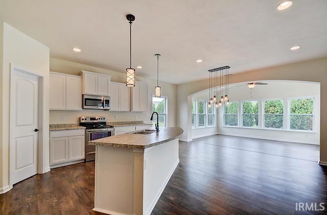 kitchen with decorative light fixtures, white cabinetry, sink, a kitchen island with sink, and stainless steel appliances