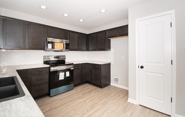 kitchen with sink, dark brown cabinets, light wood-type flooring, stainless steel appliances, and backsplash