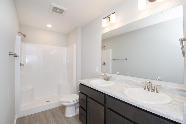 bathroom with vanity, hardwood / wood-style floors, a shower, and toilet