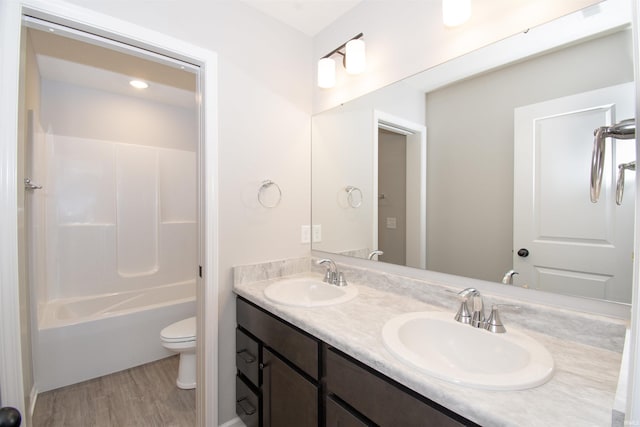 full bathroom with wood-type flooring, toilet, shower / washtub combination, and vanity