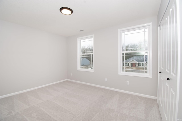 spare room featuring light colored carpet