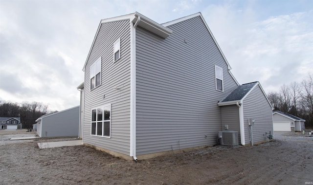 view of side of property featuring central AC, a garage, and an outdoor structure