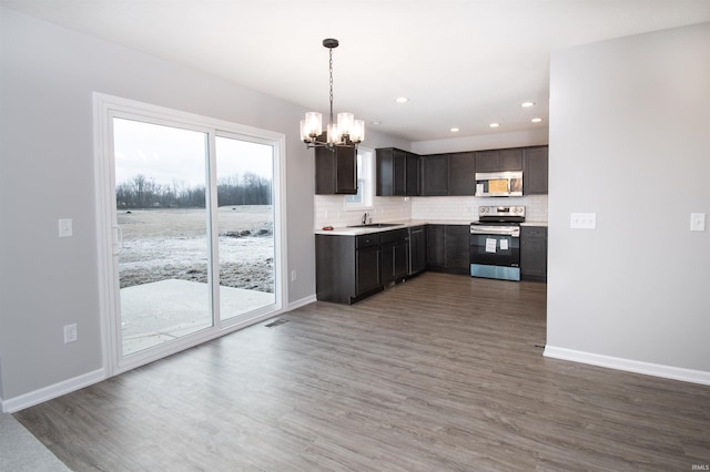 kitchen featuring dark hardwood / wood-style floors, sink, backsplash, and stainless steel electric range