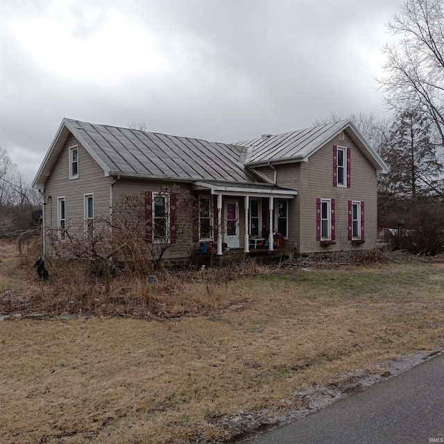 view of front of home with covered porch and a front lawn