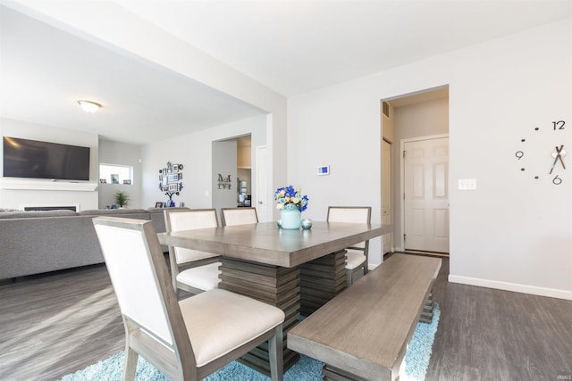 dining room featuring dark wood-style floors and baseboards