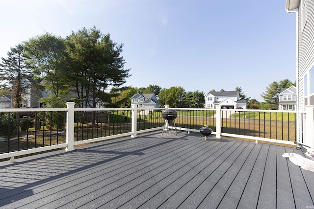 wooden deck featuring a residential view, grilling area, and a lawn