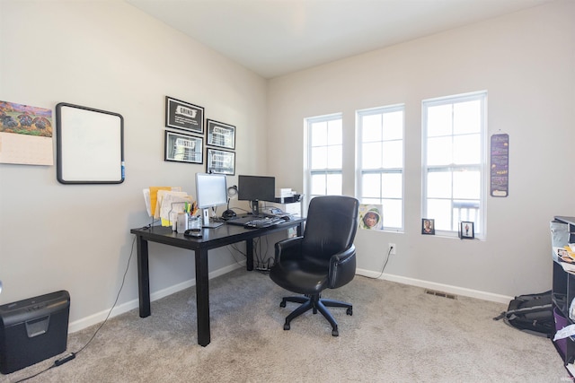 office space with baseboards, visible vents, and light colored carpet