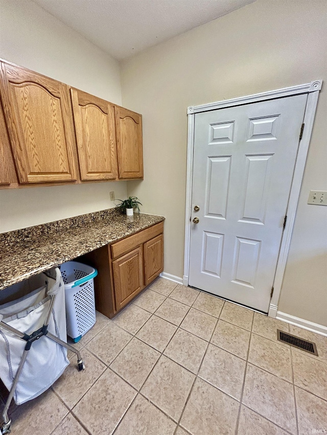 clothes washing area with light tile patterned floors