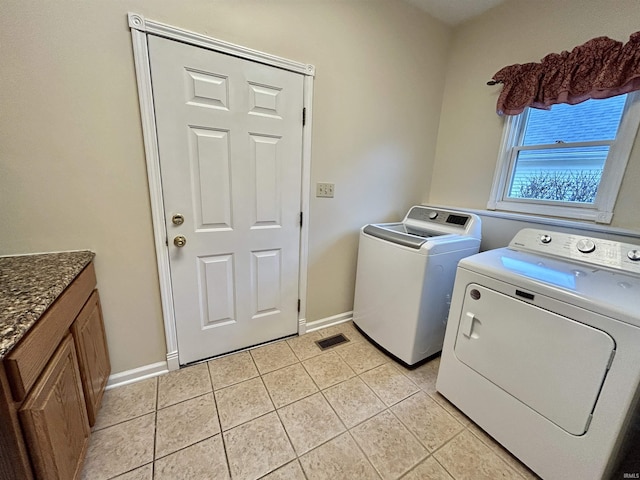 laundry area with light tile patterned flooring and washer and dryer