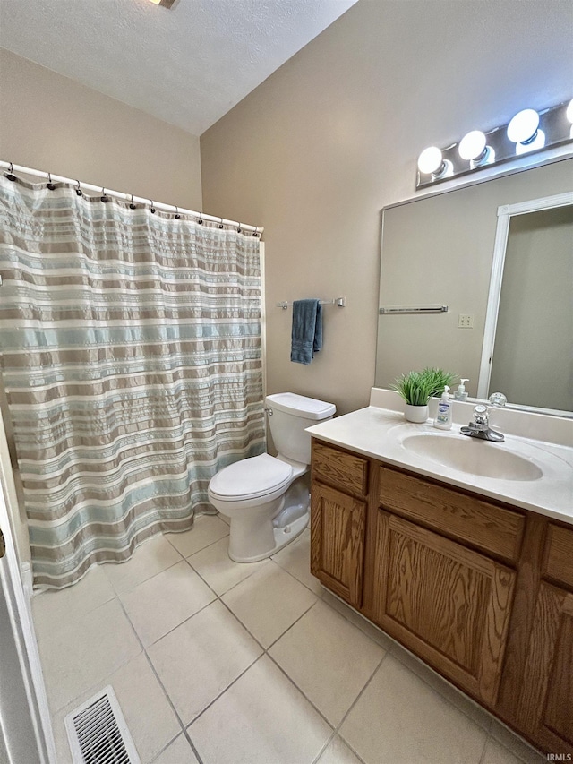 bathroom featuring vanity, tile patterned floors, and toilet