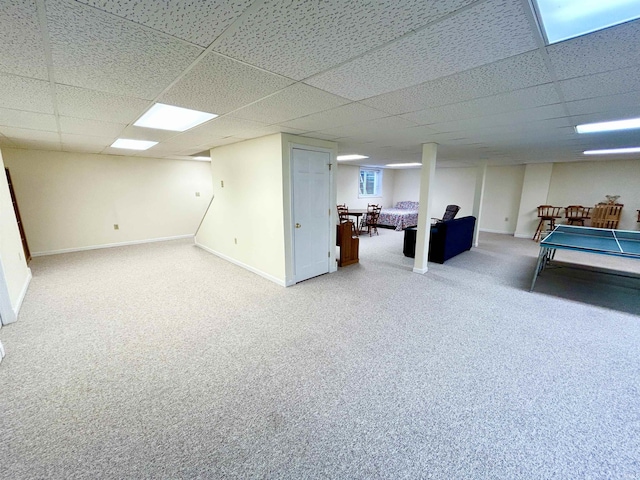 basement with a paneled ceiling and carpet