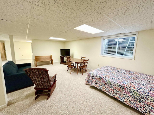 carpeted bedroom featuring a drop ceiling