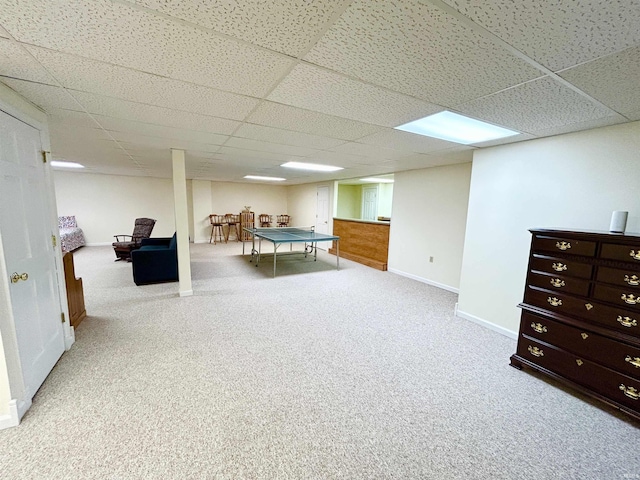 rec room with a paneled ceiling and light carpet