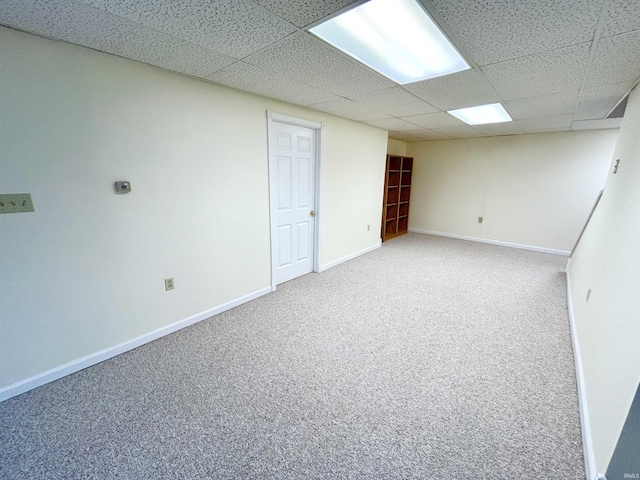 basement featuring a drop ceiling and carpet floors