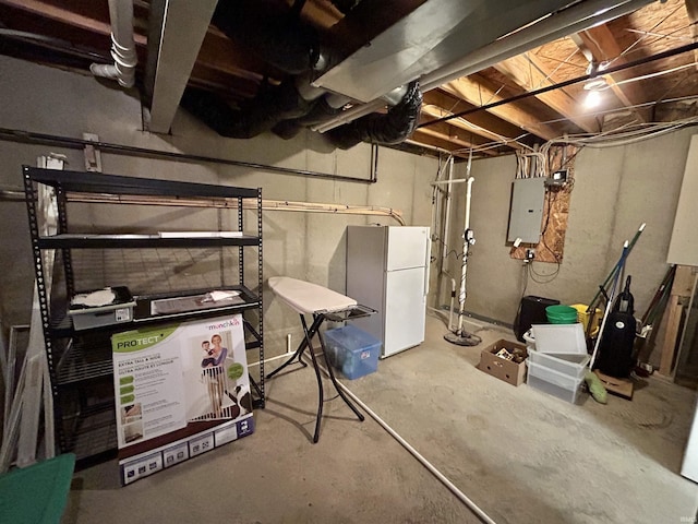 basement with electric panel and white refrigerator