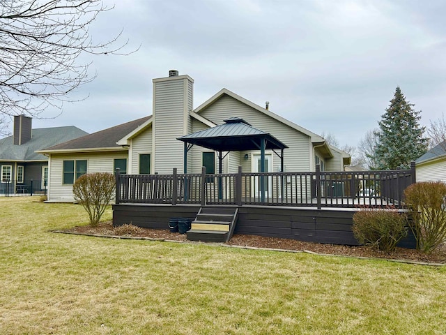 back of house with a gazebo, a deck, and a lawn