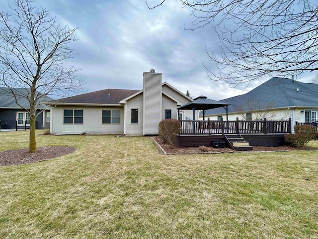 rear view of house with a yard, a gazebo, and a deck