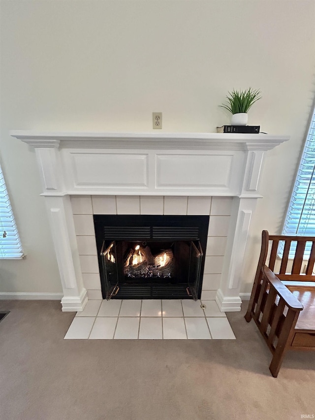 details with a tiled fireplace and carpet floors