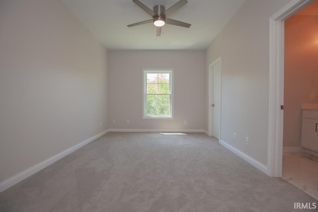 spare room featuring ceiling fan and light carpet