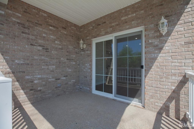 view of exterior entry featuring a patio area