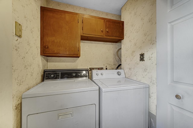 washroom featuring cabinets and washing machine and clothes dryer