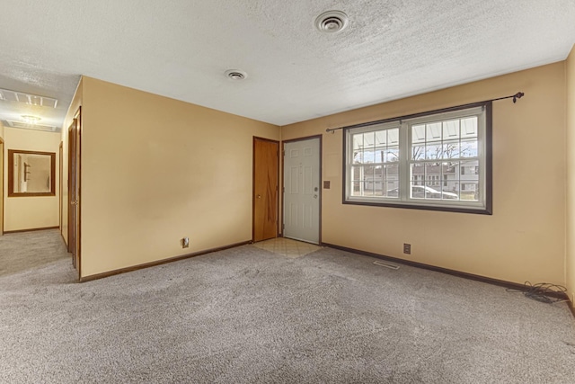 carpeted spare room with a textured ceiling