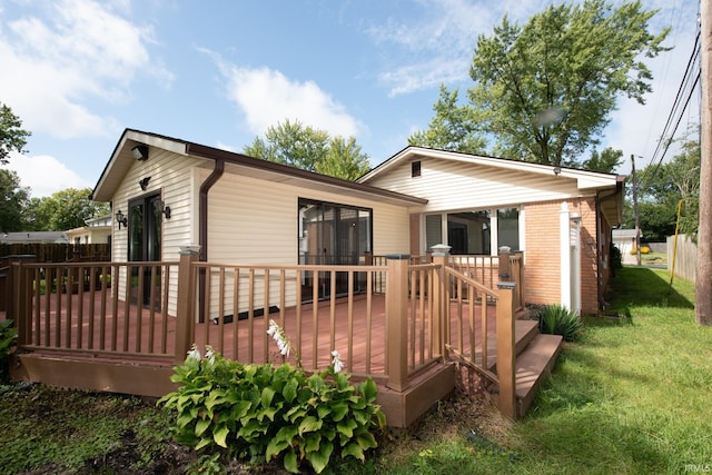 back of house featuring a wooden deck and a yard