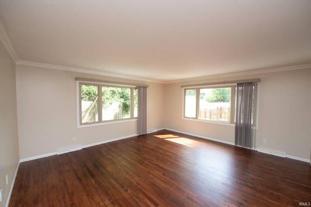 empty room with ornamental molding, a healthy amount of sunlight, and dark wood-type flooring