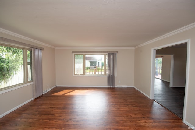 empty room featuring crown molding, plenty of natural light, and dark hardwood / wood-style floors