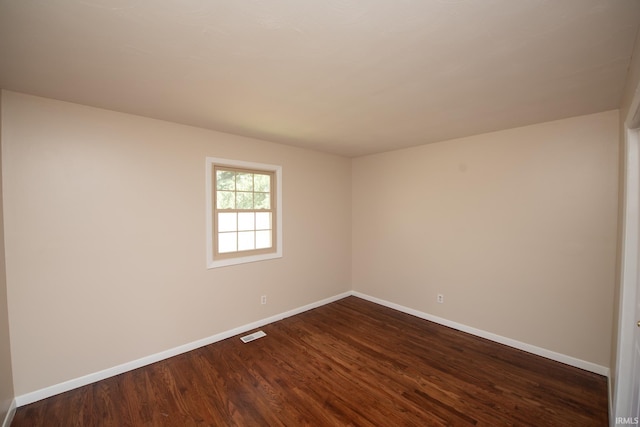 spare room featuring dark wood-type flooring