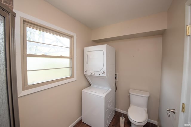 bathroom featuring stacked washer / drying machine and wood-type flooring