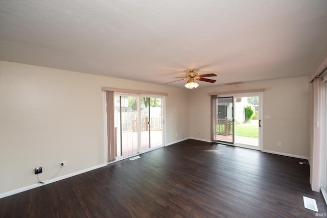 unfurnished room featuring a healthy amount of sunlight, dark hardwood / wood-style floors, and ceiling fan